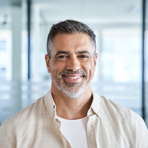 Senior man smiling and standing in office building