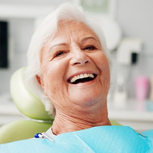Senior woman leaning back in dental chair smiling