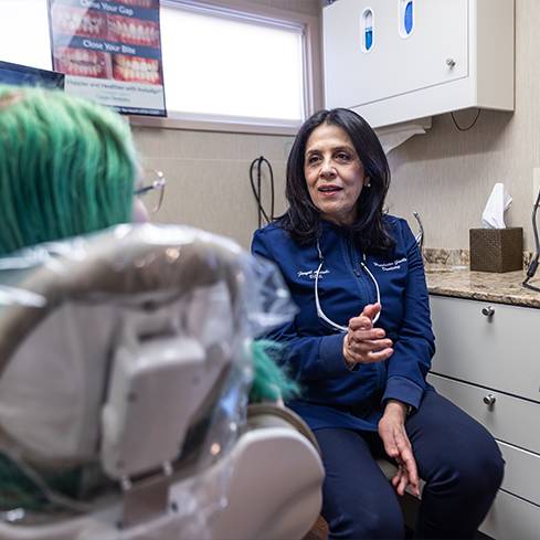 Dentist talking to a patient in the treatment chair