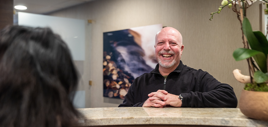Dental team member at front desk helping a woman check in
