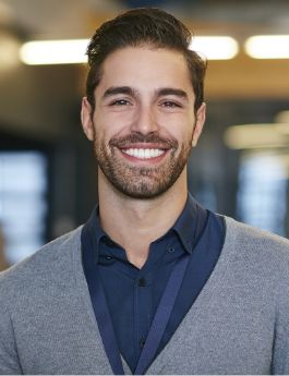 Young man in a gray cardigan smiling