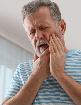 Man wincing in pain and holding the side of his face