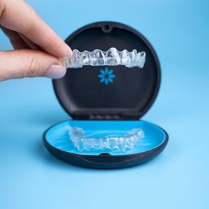 Patient lifting an Invisalign tray from its case