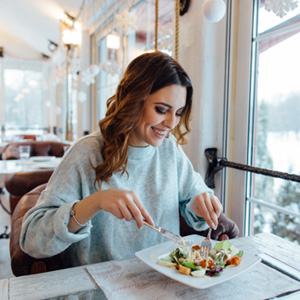 Woman smiling while enjoying lunch at restaurant