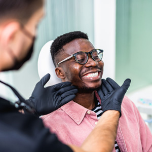 Dentist looking at patient's smile in treatment chair