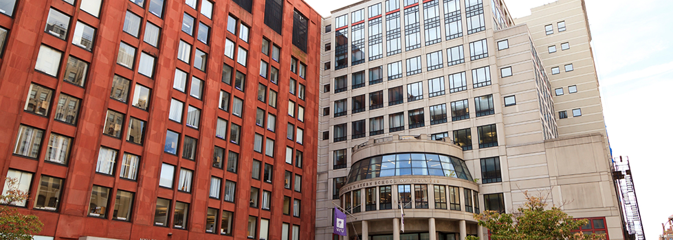 City building with a New York University flag hanging over the entrance