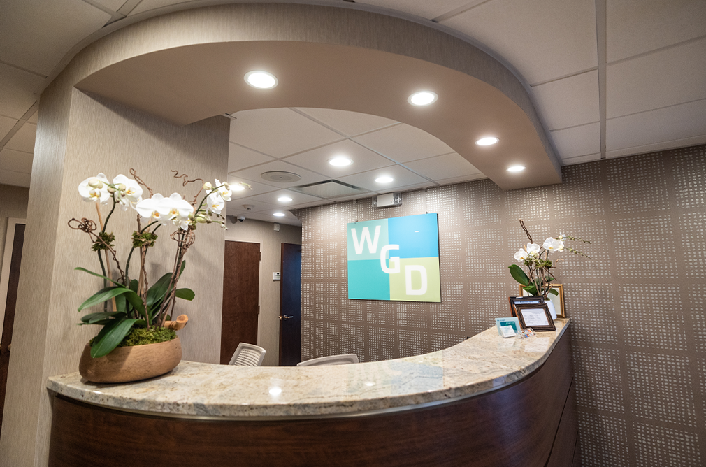 Front desk at Westchester Gentle Dentistry with two vases with white flowers on the counter