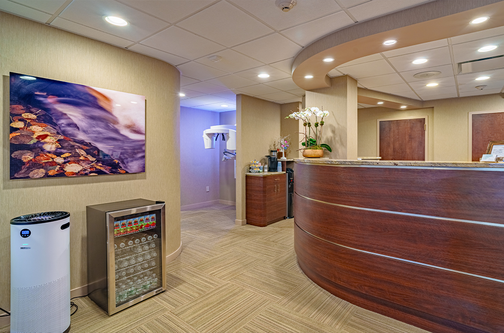 Mini fridge near the front desk with water bottles and juice boxes
