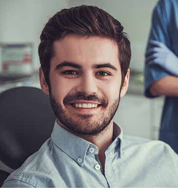 Young man smiling while sitting in the dental chair