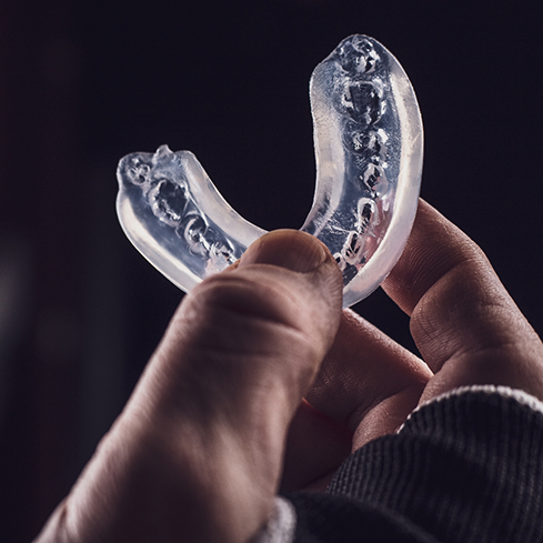 Athlete holding a clear mouthguard