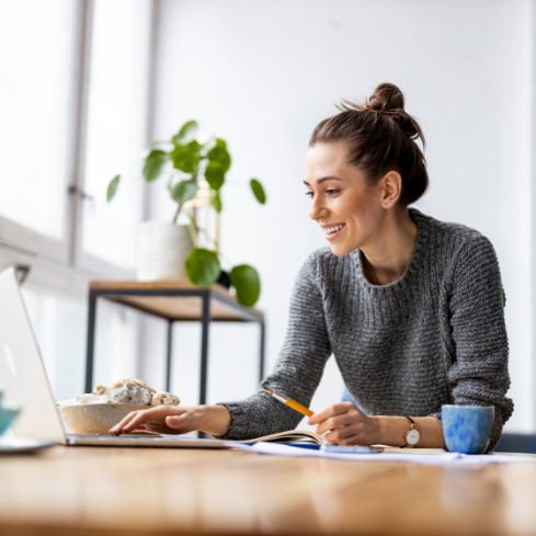 Woman smiling while using her laptop at a desk