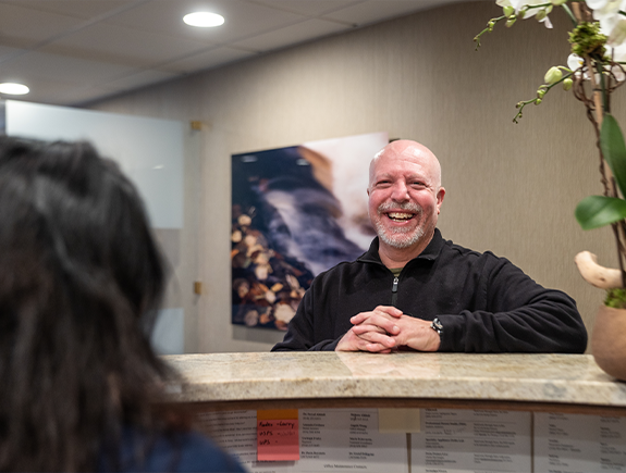 Smiling man checking in at dental office for tooth extractions