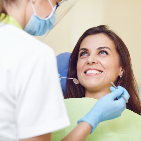 Female patient smiling up at dentist
