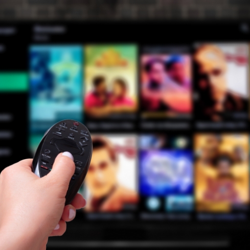 Person changing channel on tv