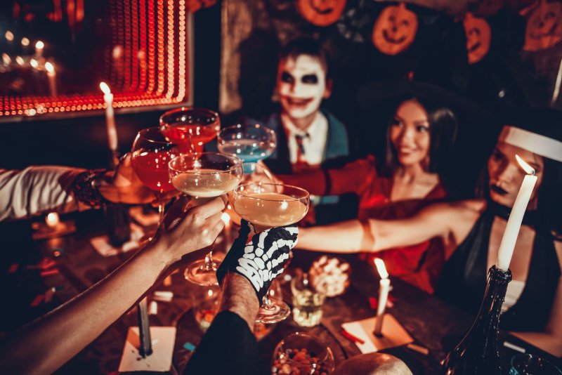 Patient with good dental health drinking with friends at Halloween party